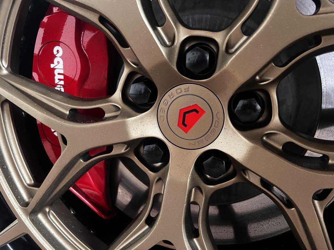 Forged custom lug nuts on Mustang Mach-E bronze alloy wheel with red Brembo brake caliper