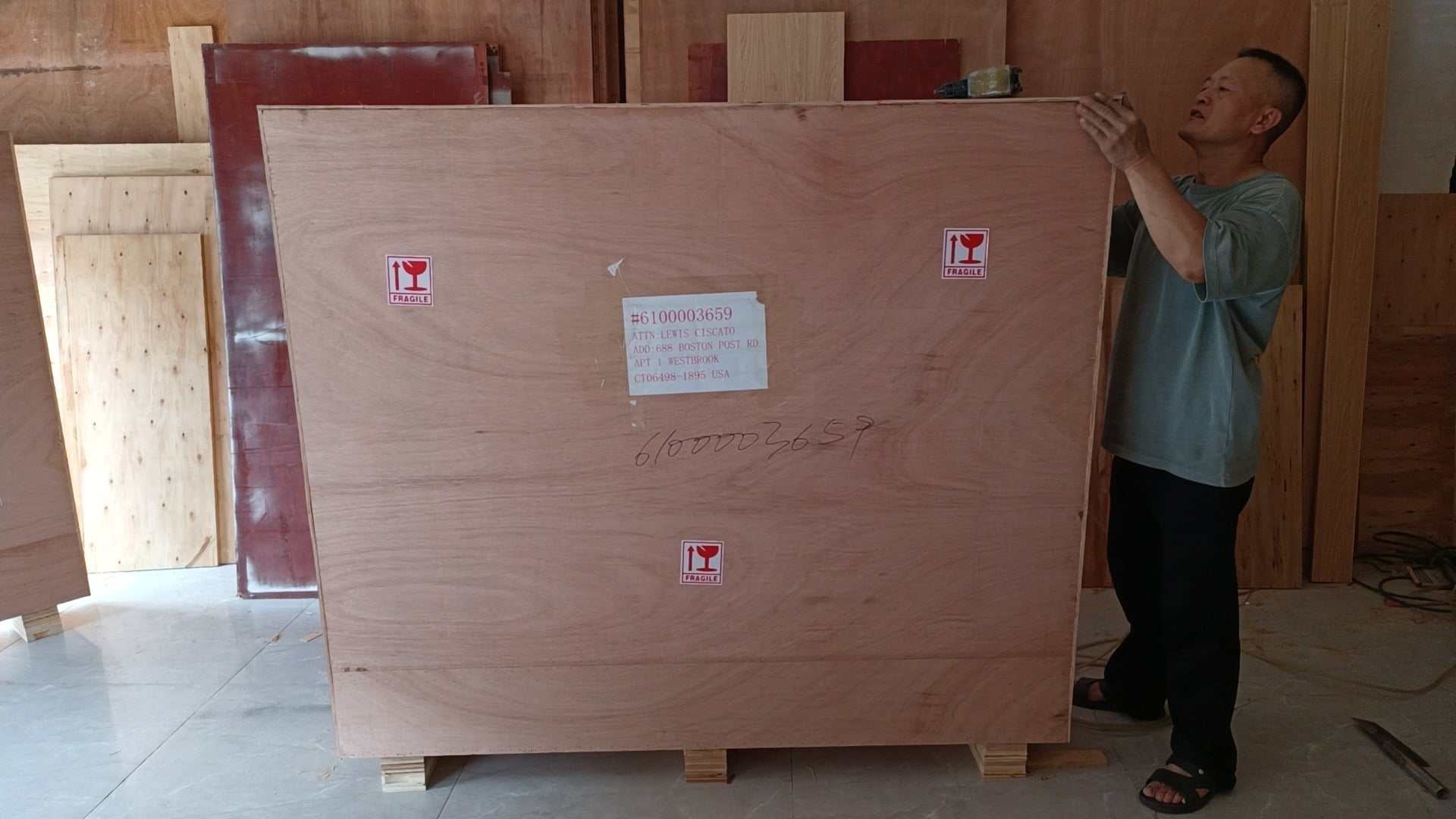 Man inspecting large wooden crate packaging for Shelby Style Fiber Hood shipping protection