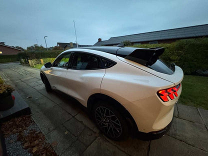 White Ford Mustang Mach-E with black Rally Wing Spoiler installed on rear roof for improved aerodynamics and sporty look