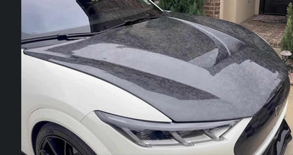 Shelby Style Fiber Hood in wet carbon fiber finish installed on white 2021-2025 Ford Mustang Mach-E with aerodynamic design and glossy texture