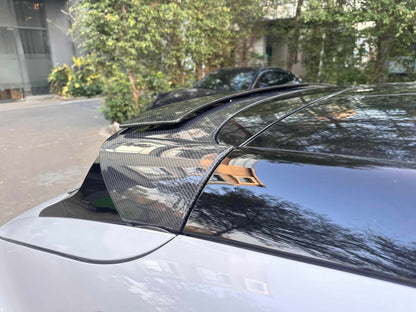 Close-up of carbon fiber retractable spoiler on black Mustang Mach-E rear trunk, enhancing aerodynamics and style