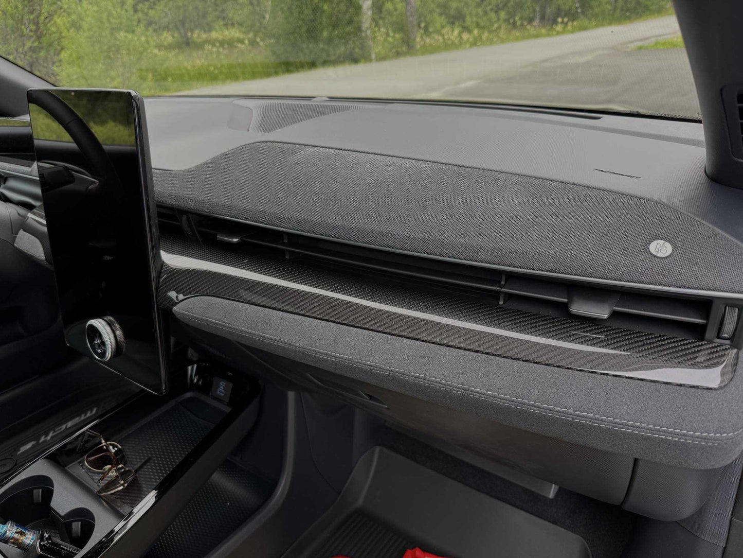 Dry carbon fiber dash panel installed on a 2021-2025 Ford Mustang Mach-E interior.