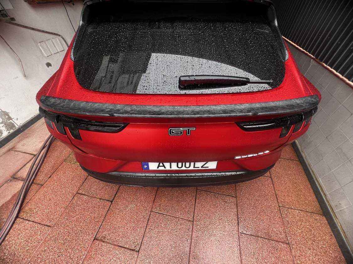 Rear view of red Mustang Mach-E with wet carbon fiber Spoiler V2 installed
