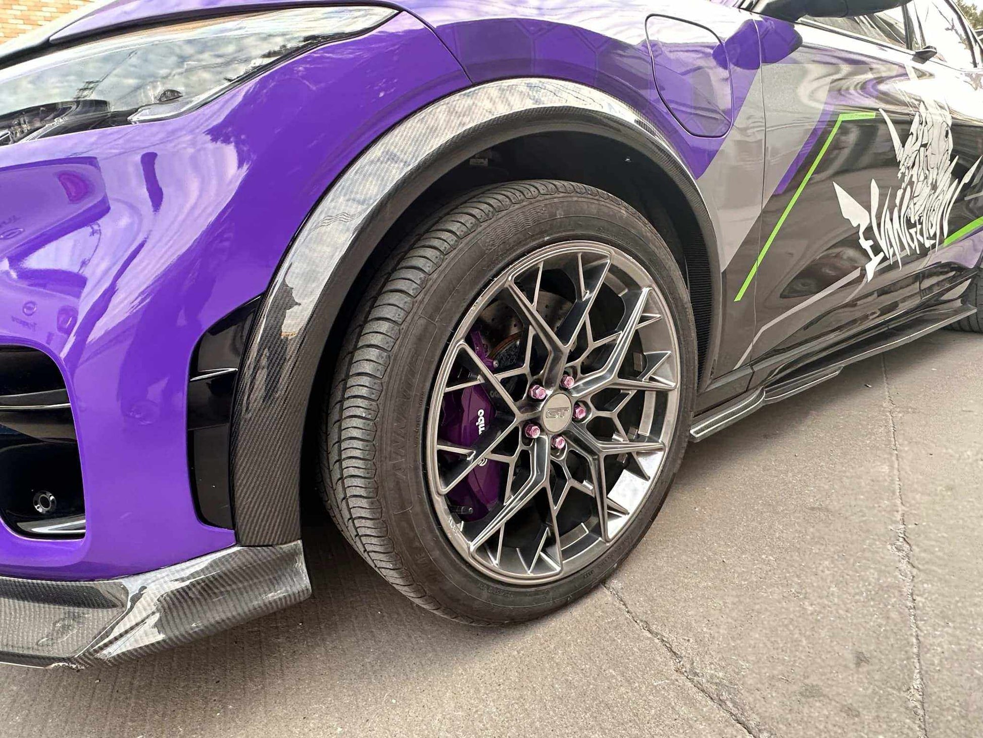 Close-up of a purple car with black carbon wider fender flares and custom alloy wheel with purple brake caliper