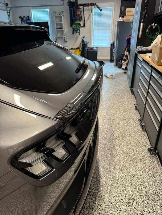 Spoiler V2 carbon fiber installed on rear of silver Mustang Mach-E in garage