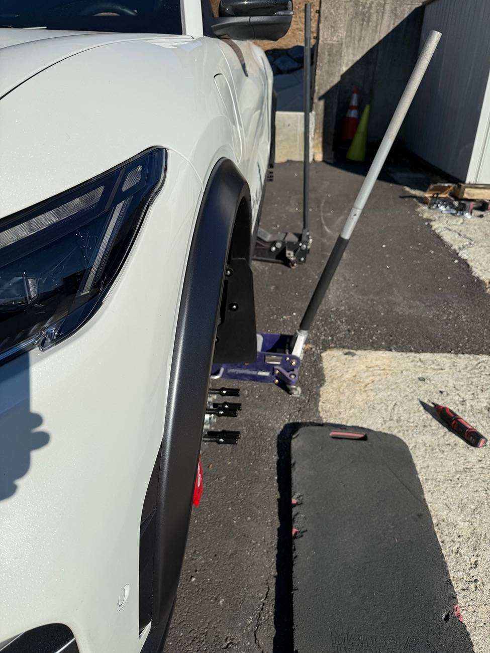 White vehicle fitted with black wider fender flares installed for enhanced tire clearance and aggressive look