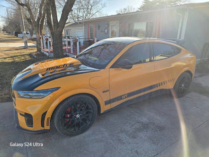 Yellow Ford Mustang Mach-E with black GT550 style fiber hood and vents in a driveway