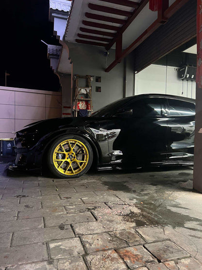 Black Ford Mustang Mach-E GT with gold wheels equipped with carbon ceramic disc rotors and drilled brake rotors in garage