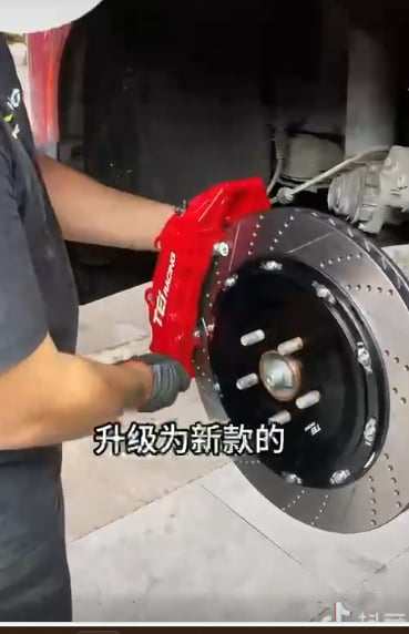 Front drilled carbon ceramic disc rotor with red Brembo caliper installation on Ford Mustang Mach-E brake system