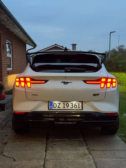 Ford Mustang Mach-E rear view showcasing Rally Wing Spoiler in black with illuminated taillights
