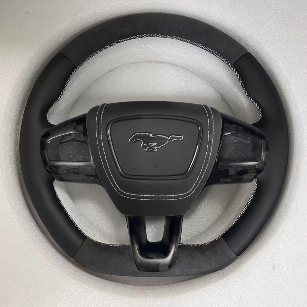 Custom made steering wheel for Mustang Mach-E with leather and Alcantara grip, carbon fiber accents, and hand-stitched details.