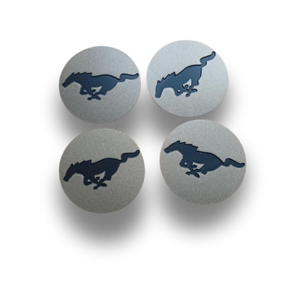 Set of four forged metal Mach-E center caps with raised Mustang horse logo, designed for precision fit and enhanced wheel style.