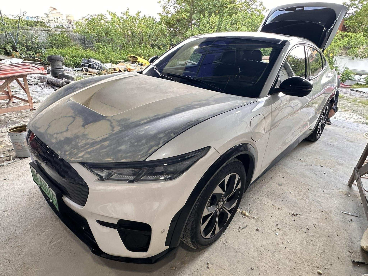 Ford Mustang Mach-E with a Shelby Style Fiber Hood in carbon fiber finish parked outdoors