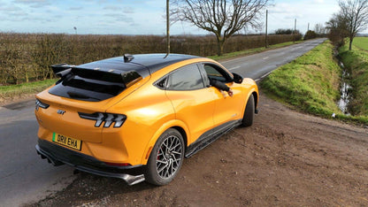 Ford Mustang Mach-E with black Rally Wing Spoiler on rear, parked on rural road edge