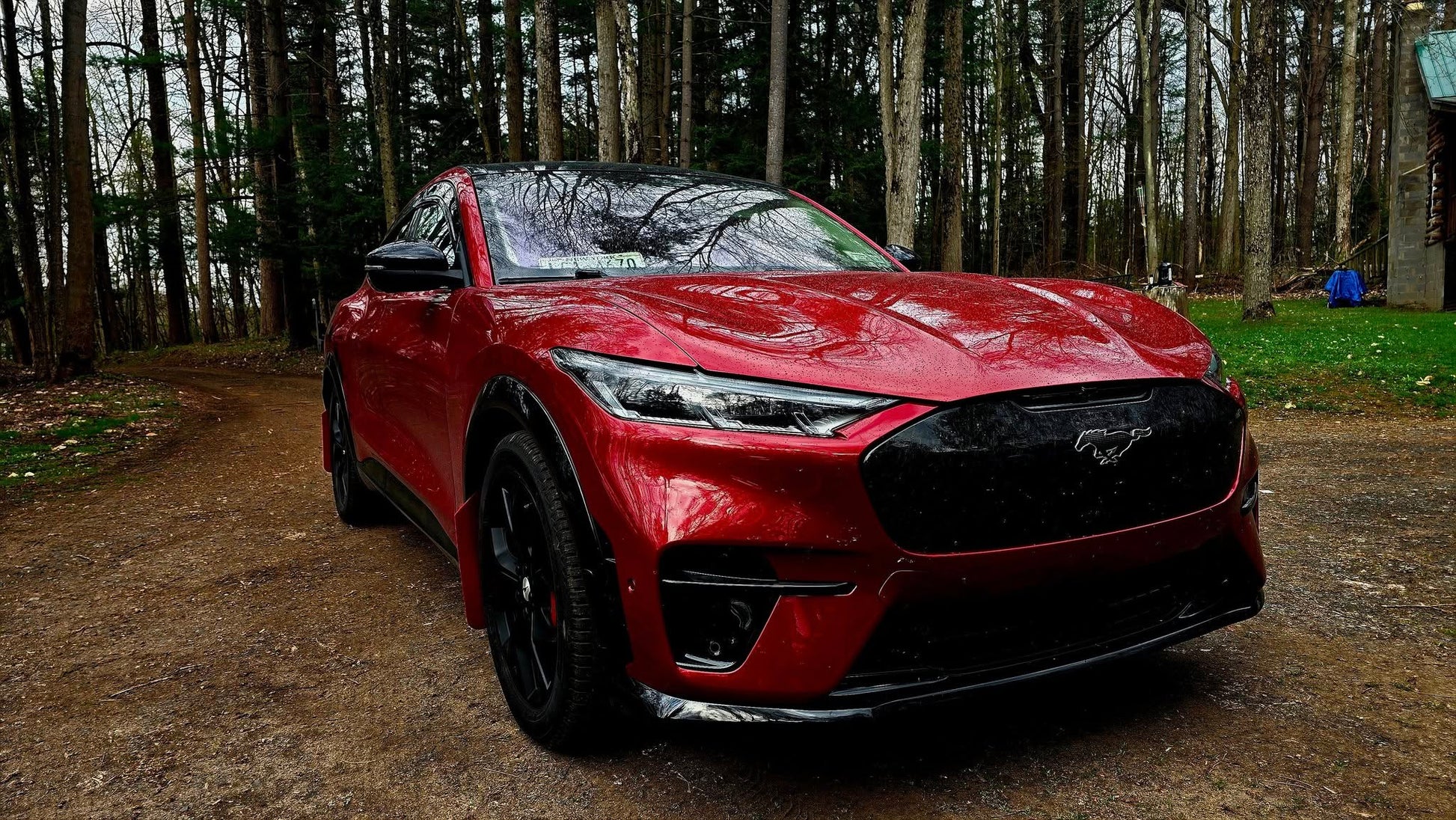 Red Mustang Mach-E with GT bumper front replacement featuring carbon grill and lit pony emblem