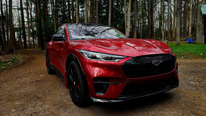 Red Mustang Mach-E with GT bumper front replacement featuring carbon grill and lit pony emblem