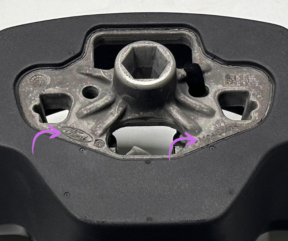 Close-up of Ford OEM Yoke Steering Wheel metal mounting hub for Mustang Mach-E with Ford logo and part number engravings.